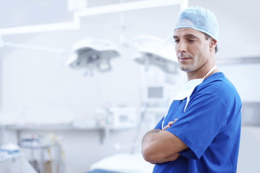 Medical professional in blue scrubs on the right hand side, with an operating room in the background. This is above an article detailing how our HIPPA-certified answering service works for you and your business.