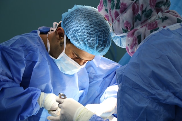 Cosmetic surgeon performing a plastic surgery procedure in a sterile operating room setting